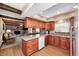Eat-in kitchen with stained cabinets, stone countertops, and a view into the living room at 7170 Janean Dr, Brownsburg, IN 46112