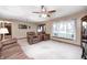 Comfortable living room featuring neutral tones, a ceiling fan, and large windows offering backyard views at 7170 Janean Dr, Brownsburg, IN 46112