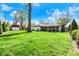 Large, well-maintained backyard with lush green grass, mature trees, and a glimpse of the patio at 731 Oak Dr, Greenwood, IN 46142
