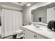 Bright bathroom with white cabinetry, decorative mirror, neutral walls, and a shower behind a curtain at 731 Oak Dr, Greenwood, IN 46142