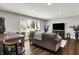 Comfortable living room with a large window, a brown sofa, wood floors, and a dining table with chairs at 731 Oak Dr, Greenwood, IN 46142