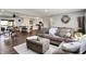 Open-concept living room with comfortable brown sofas, wood floors, an area rug, and a view into the kitchen at 731 Oak Dr, Greenwood, IN 46142
