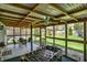 View of the screened-in patio with ceiling fans and a foosball table overlooking the lush backyard at 731 Oak Dr, Greenwood, IN 46142