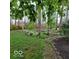 View of the backyard surrounded by mature trees, green grass and a patio path at 7594 W Williamswood Dr, New Palestine, IN 46163