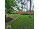 Lush backyard with a brick patio, mature trees, and a relaxing garden bench for enjoying the outdoors at 7594 W Williamswood Dr, New Palestine, IN 46163