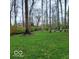 Serene backyard setting with mature trees, lush lawn, and plenty of privacy for relaxation and recreation at 7594 W Williamswood Dr, New Palestine, IN 46163