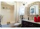 Well-lit bathroom with a combination shower-tub, ornate mirror, dark vanity, and decorative accents at 7594 W Williamswood Dr, New Palestine, IN 46163