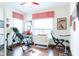 Bright bedroom featuring hardwood floors, a ceiling fan, and large windows dressed with a red and white valance at 7594 W Williamswood Dr, New Palestine, IN 46163