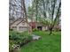 Charming brick home featuring a well-manicured lawn, mature trees, and an attached two-car garage at 7594 W Williamswood Dr, New Palestine, IN 46163