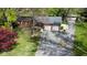 Aerial view of a brick home featuring an attached two-car garage, long driveway, and well-manicured lawn with mature trees at 7825 N County Road 650 E, Brownsburg, IN 46112
