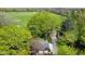 Aerial view of property featuring a home, detached garage, tractor, driveway and large open fields at 7825 N County Road 650 E, Brownsburg, IN 46112