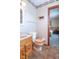 Classic bathroom with wood vanity, tile flooring, toilet, shelf, and painted walls at 7825 N County Road 650 E, Brownsburg, IN 46112