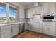 Kitchen with gray cabinets, stainless appliances and sink below a large picture window at 8083 Easton Ln, Zionsville, IN 46077