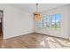 Sunlit dining room with hardwood floors and a stylish wicker chandelier fixture at 8083 Easton Ln, Zionsville, IN 46077