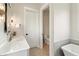 Modern bathroom with a marble countertop sink and a view into the toilet and bathtub area at 8083 Easton Ln, Zionsville, IN 46077