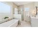 Bright bathroom featuring a soaking tub, glass shower, and double vanity at 8083 Easton Ln, Zionsville, IN 46077