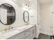 Bathroom with double sink, marble countertops, and stylish mirrors at 8083 Easton Ln, Zionsville, IN 46077