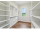 Bright walk-in closet with custom shelving and wood floors at 8083 Easton Ln, Zionsville, IN 46077