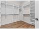Organized walk-in closet with custom shelving and hardwood floors for a functional storage space at 8083 Easton Ln, Zionsville, IN 46077