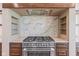 Close-up of stainless steel range with marble backsplash, custom hood and open shelving at 8083 Easton Ln, Zionsville, IN 46077
