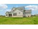 Rear exterior view of home features a light gray facade, stone accents, and a covered patio at 8083 Easton Ln, Zionsville, IN 46077