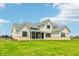 Rear exterior view of home features light gray facade, large backyard and covered patio at 8083 Easton Ln, Zionsville, IN 46077