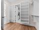 Spacious walk-in closet with custom shelving and cabinets leading to bathroom and utility room at 8083 Easton Ln, Zionsville, IN 46077