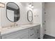 Bright bathroom featuring double sinks, marble counters, and oval mirrors at 8083 Easton Ln, Zionsville, IN 46077