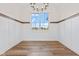 Bright dining area featuring wainscoting, chandelier, wood floors, and window with neighborhood views at 8083 Easton Ln, Zionsville, IN 46077