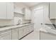 Laundry room featuring granite countertops, white cabinets and gold fixtures at 8083 Easton Ln, Zionsville, IN 46077