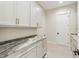 Functional laundry room with stylish white cabinetry and granite countertops at 8083 Easton Ln, Zionsville, IN 46077