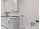 Well-lit laundry room featuring ample cabinet space, gray countertops, and connections for a washer and dryer at 8083 Easton Ln, Zionsville, IN 46077