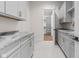Bright laundry room featuring gray cabinets, marbled countertops, and an open doorway to a walk-in closet at 8083 Easton Ln, Zionsville, IN 46077