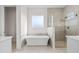 Luxurious bathroom featuring a freestanding tub, glass-enclosed shower, and natural light at 8083 Easton Ln, Zionsville, IN 46077