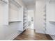 Walk-in closet with custom shelving and hardwood floors, leading to a bathroom at 8083 Easton Ln, Zionsville, IN 46077