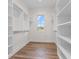 Spacious walk-in closet with custom shelving and a window offering natural light at 8083 Easton Ln, Zionsville, IN 46077