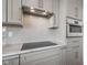 Modern kitchen features gray cabinets, tile backsplash, stainless steel range hood, and elegant marble countertops at 8083 Easton Ln, Zionsville, IN 46077