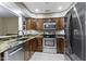 Modern kitchen with granite countertops, stainless steel appliances, and dark wood cabinetry at 8651 Jaffa Court East Dr # 18, Indianapolis, IN 46260