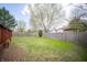 Large, fenced backyard with green grass, mature trees, and a spacious wooden deck perfect for outdoor entertaining at 9143 Warwick Rd, Indianapolis, IN 46240
