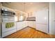 Cozy white kitchen featuring a vintage stove, subway tile backsplash, and wood floors at 9143 Warwick Rd, Indianapolis, IN 46240