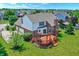An aerial view showcases the large backyard with a deck, mature trees, and the home's brick and siding exterior at 9318 Windrift Way, Zionsville, IN 46077