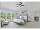 This modern bedroom features a ceiling fan, bench, chair, and large windows with natural light at 9318 Windrift Way, Zionsville, IN 46077
