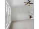 Bright bedroom with a ceiling fan and attached bathroom featuring an open doorway and large windows at 9318 Windrift Way, Zionsville, IN 46077
