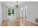 Bright dining room with hardwood floors, chandelier, and a large window at 9318 Windrift Way, Zionsville, IN 46077