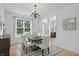 Dining room with a modern chandelier, large window, and a neutral color scheme, creating an inviting space at 9318 Windrift Way, Zionsville, IN 46077