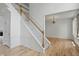 Bright foyer with a staircase featuring white trim and wood railing, complemented by hardwood floors at 9318 Windrift Way, Zionsville, IN 46077