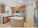 The kitchen includes wood cabinets, stainless steel appliances, an island and light hardwood floors at 9318 Windrift Way, Zionsville, IN 46077