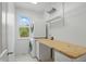 Efficient laundry room with a stacked washer/dryer and built-in wooden counter offers functionality at 9318 Windrift Way, Zionsville, IN 46077