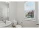 Clean powder room featuring a pedestal sink and a window, maximizing natural light at 9318 Windrift Way, Zionsville, IN 46077