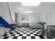 Open basement area featuring an exercise bike, ample lighting, and checkered flooring at 933 Hummingbird Ln, Columbus, IN 47203